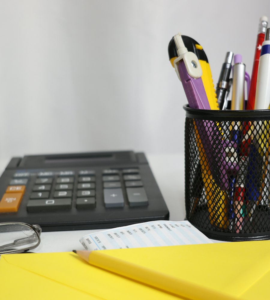 Mesa de trabalho com calculadora e documentos contábeis organizados