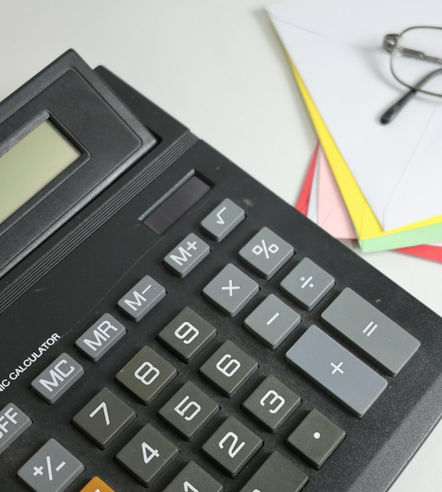 Calculadora sobre papéis coloridos representando a apuração de novos tributos