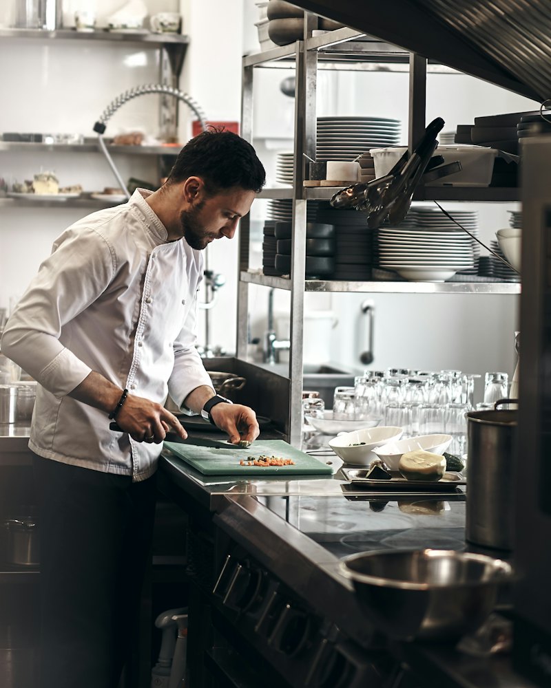 Cozinheiro preparando alimentos na cozinha de um restaurante